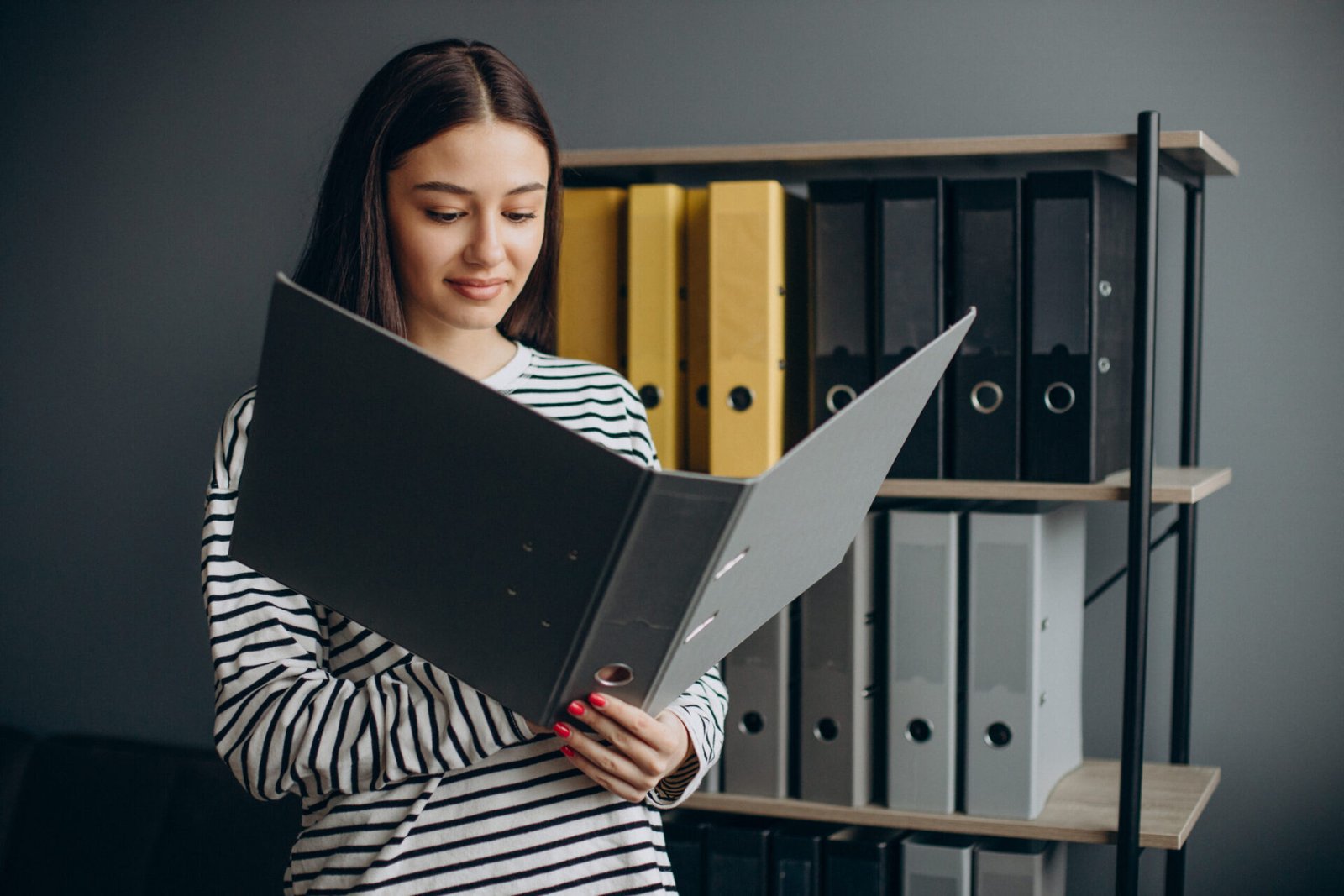 Young woman working with documents and checking archives